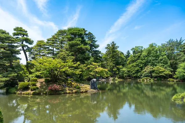 Kanazawa 'daki Kenroku-en Bahçesi, sakin manzaralı çam ağaçları, berrak sular ve huzurlu bir gölet etrafında dikkatlice yerleştirilmiş mevsimlik bitkiler sunar.
