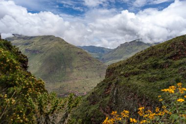 Yeşil yemyeşil dağlar Kutsal Vadi 'yi Pisac arkeolojik alanının yakınına kurar. Manzara, bölgenin zengin biyolojik çeşitliliğini ve antik uygarlıklar tarafından kullanılan tarlaları sergiliyor.