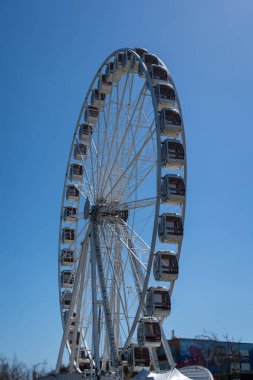 Kapalı kulübeleri olan büyük bir dönme dolap Fisherman Wharf, San Francisco 'da mavi gökyüzüne karşı duruyor ve liman ve şehrin panoramik manzarasını sağlıyor.