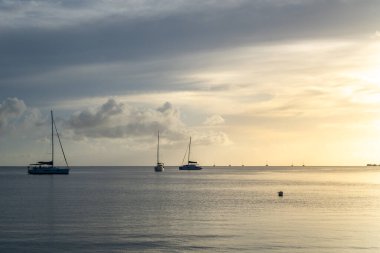 Fransız Polinezyası 'ndaki Tahaa Adası' nda sakin sular ve sakin bir atmosfer yaratan yelkenli tekneleriyle güzel bir günbatımı.