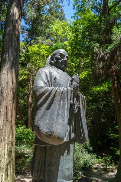 Hiroşima 'daki Mitaki-Dera Tapınağı' nın ormanlarında ağırbaşlı bir şekilde duran uzun bronz keşiş heykelleri barış ve hürmet saçıyor.