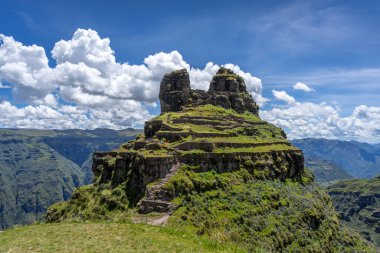 Peru 'daki Waqrapukara arkeolojik sahasında engebeli bir dağ zirvesinde, Andean manzarasının çarpıcı manzaralarını sunan teraslı taş kalıntıları yer almaktadır.