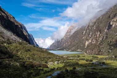 Yükselen dağlar arasında yemyeşil bir vadi uzanır, sakin bir göle uzanan dolambaçlı bir nehir. Bu nefes kesici manzara, Peru, Huaraz 'daki Laguna 69 yürüyüşünün bir parçası.