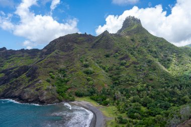 Hiva Oa, Marquesas Adaları, Fransız Polinezyası 'ndaki Puamau kıyısında sarp kayalıklar, yemyeşil tepeler ve Pasifik Okyanusu' nda turkuaz suyu bulunan tenha bir koy bulunur.