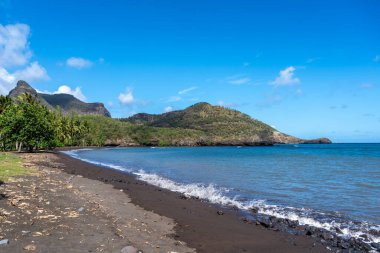Hakaui Körfezi, Nuku Hiva, Marquesas Adaları, Fransız Polinezyası 'nda tenha bir kumsal. Yükselen kayalıklar, yemyeşil bitki örtüsü ve sallanan palmiye ağaçları çarpıcı bir tropik cennet yaratır.