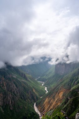 Peru 'daki Colca Kanyonu' nun ve nehrin büyüleyici manzarasını saran sis, sarp dağlar ve dağlarla kaplıyor.