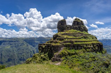 Peru 'daki Waqrapukara arkeolojik sahasında engebeli bir dağ zirvesinde, Andean manzarasının çarpıcı manzaralarını sunan teraslı taş kalıntıları yer almaktadır.