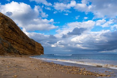 Avustralya 'nın Büyük Okyanus Yolu üzerindeki Aireys Körfezi' ndeki Bells Beach 'te altın kum, dağınık kayalar ve yüksek uçurumlar bulunur. Mavi okyanus dramatik bulutlarla dolu uçsuz bucaksız bir gökyüzü ile karşılaşıyor, çarpıcı bir kıyı manzarası yaratıyor.