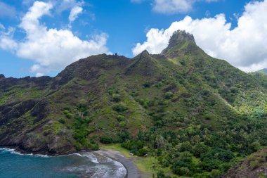 Hiva Oa, Marquesas Adaları, Fransız Polinezyası 'ndaki Puamau kıyısında sarp kayalıklar, yemyeşil tepeler ve Pasifik Okyanusu' nda turkuaz suyu bulunan tenha bir koy bulunur.