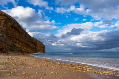Avustralya 'nın Büyük Okyanus Yolu üzerindeki Aireys Körfezi' ndeki Bells Beach 'te altın kum, dağınık kayalar ve yüksek uçurumlar bulunur. Mavi okyanus dramatik bulutlarla dolu uçsuz bucaksız bir gökyüzü ile karşılaşıyor, çarpıcı bir kıyı manzarası yaratıyor.