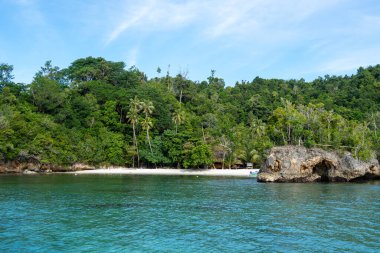 Sulawesi, Endonezya 'daki güzel Togian takımadasının bir parçası olan Waleakodi Adası' ndaki Lia plajının beyaz kumlarında renkli bir pirogue bulunur.