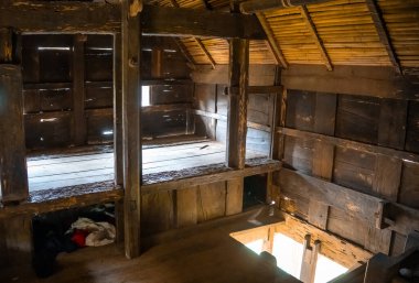 Bambu tavanı ve asgari gün ışığıyla geleneksel bir Toraja evinin ahşap iç kısmı, Endonezya, Sulawesi 'deki kırsal yaşam tarzını yansıtıyor.