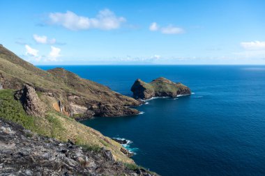 Marquesas Adaları 'ndaki Nuku Hiva' daki Taiohae Körfezi 'nin engebeli uçurumları parlak bir gökyüzünün altından çıkan küçük kayalık adalarla derin mavi Pasifik Okyanusu' na düşer. Fransız Polinezyası
