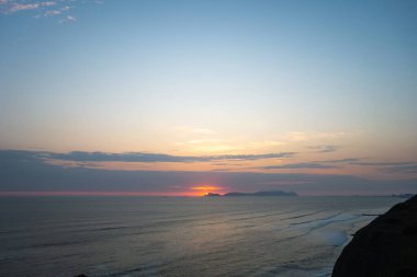 Güneş San Lorenzo adasının üzerinde batarken Pasifik Okyanusu 'na ve Peru' nun yeşil kayalıklarına altın bir parıltı saçtı. Huzurlu kıyı manzarası nefes kesici bir doğa manzarası sunuyor güzellik ve sükunet.