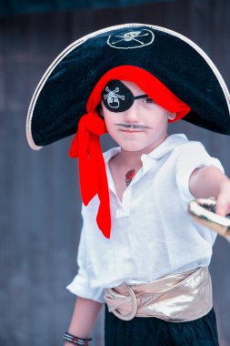 Korsan gibi giyinmiş küçük çocuk oynamaya hazır.