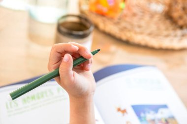 Solak çocuk kalemini tutuyor.