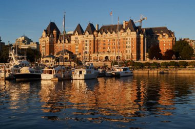 Botlar, tarihi Fairmont İmparatoriçe Oteli 'nin önüne yanaştı Victoria, Vancouver Adası, Kanada' da günbatımında..