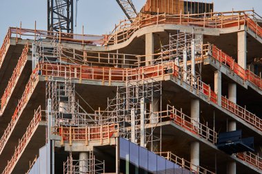 Victoria, Vancouver Adası şehir merkezinde inşaat halindeki, cam iskeleli ve yansıtıcı cepheli modern bir gökdelenin yakın görüntüsü..