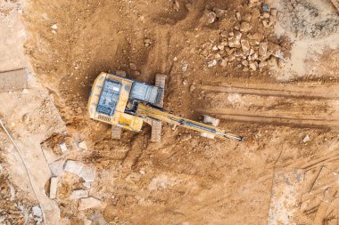 İnşaat alanında toprak hareketinde kazıcı, hava manzarası.