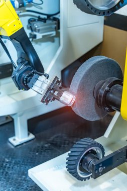 Üretim hattı arasındaki metal mekanizmalı kuyu parçalarını tutan robotik kol. otomotiv parçaları üretim süreci. 