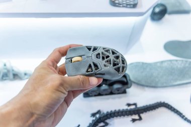 3D yazıcıya yazdırılmış içi boş bilgisayar faresi nesnesi olan el