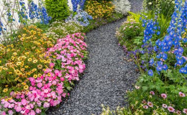 Çiçek bahçesinden geçen kayalık yollu renkli çiçekler.