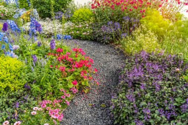 Çiçek bahçesinden geçen kayalık yollu renkli çiçekler.