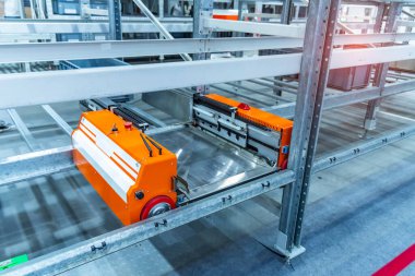 Depodaki otomasyon bir robot yükleyici robotu kontrol ediyor ve kutuları taşıyor