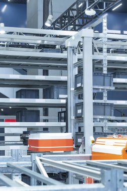 Depodaki otomasyon bir robot yükleyici robotu kontrol ediyor ve kutuları taşıyor