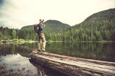 Bir adam sakin gölün yanında dinleniyor. Rahatlama tatili