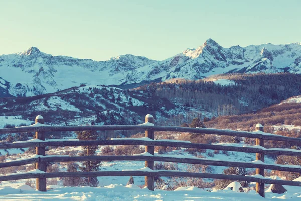 冬の山の中で雪に覆われたフェンス — ストック写真