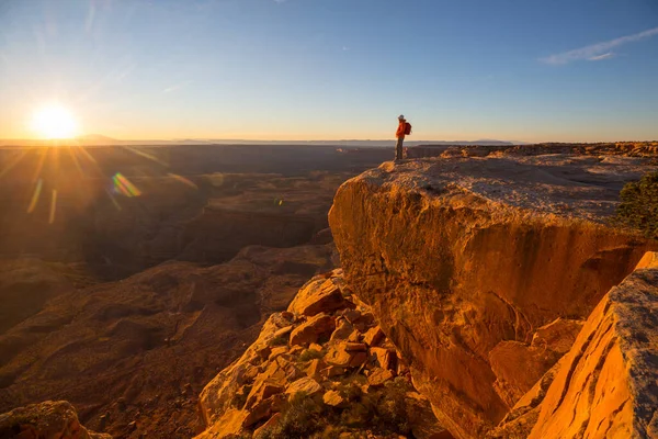 日の出の山の崖の上の男 ハイキングシーン — ストック写真