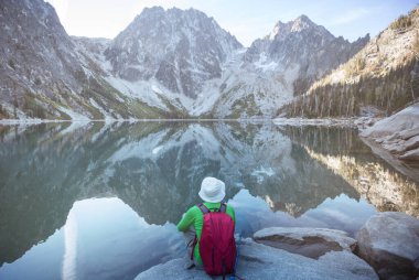 Bir adam sakin gölün yanında dinleniyor. Rahatlama tatili