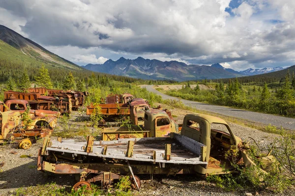 カナダ北部の夏の間に荒野で錆びた放棄された戦後のトラックの配列 — ストック写真