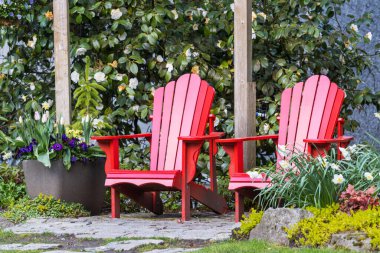 Red comfortable deck chairs in the spring garden  in Canada.