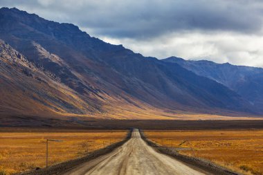 Sonsuz Dempster karayolu yakınındaki Kuzey Kutup dairesi, Dawson City Inuvik, Kanada için önde gelen uzak çakıl yol