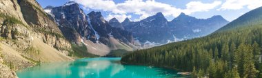 Moraine Gölü 'nün turkuaz suları. Kanada' nın Banff Ulusal Parkı 'nda karla kaplı tepeleri var.