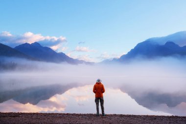 Bir adam sakin gölün yanında dinleniyor. Rahatlama tatili