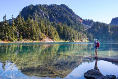 Bir adam sakin gölün yanında dinleniyor. Rahatlama tatili