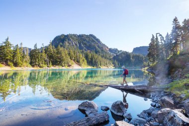 Bir adam sakin gölün yanında dinleniyor. Rahatlama tatili