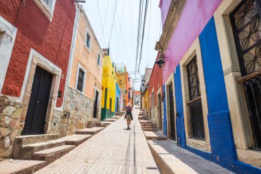 Meksika 'nın ünlü Guanajuato şehrindeki renkli caddede bir turist.