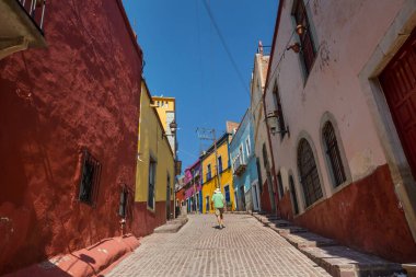 Meksika 'nın ünlü Guanajuato şehrindeki renkli caddede bir turist.
