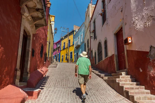 Meksika 'nın ünlü Guanajuato şehrindeki renkli caddede bir turist.