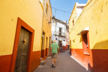 Meksika 'nın ünlü Guanajuato şehrindeki renkli caddede bir turist.