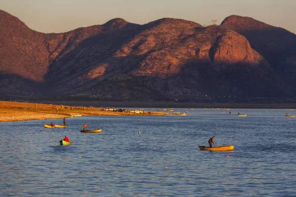 日の出に湖の上のボートの漁師たち — ストック写真