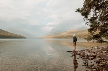 Bir adam sakin gölün yanında dinleniyor. Rahatlama tatili