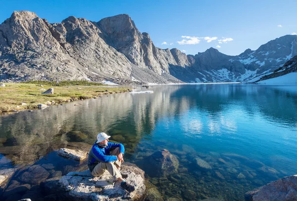 穏やかな湖のそばで男が寛いでいる リラクゼーション休暇 — ストック写真