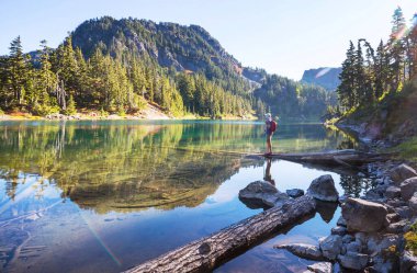 Bir adam sakin gölün yanında dinleniyor. Rahatlama tatili