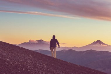 Şili 'de gün batımında volkanlar arasındaki erkekler