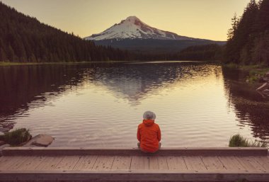 Bir adam sakin gölün yanında dinleniyor. Rahatlama tatili
